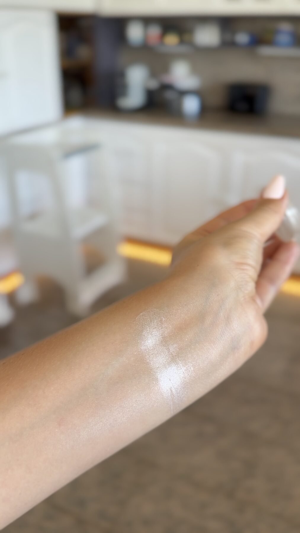 Close-up of a forearm with a shimmery luminizer swatch rubbed onto the skin.